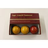 A boxed set of three billiard balls