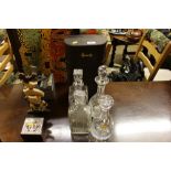 Four glass decanters and a Harrod's two bottle car