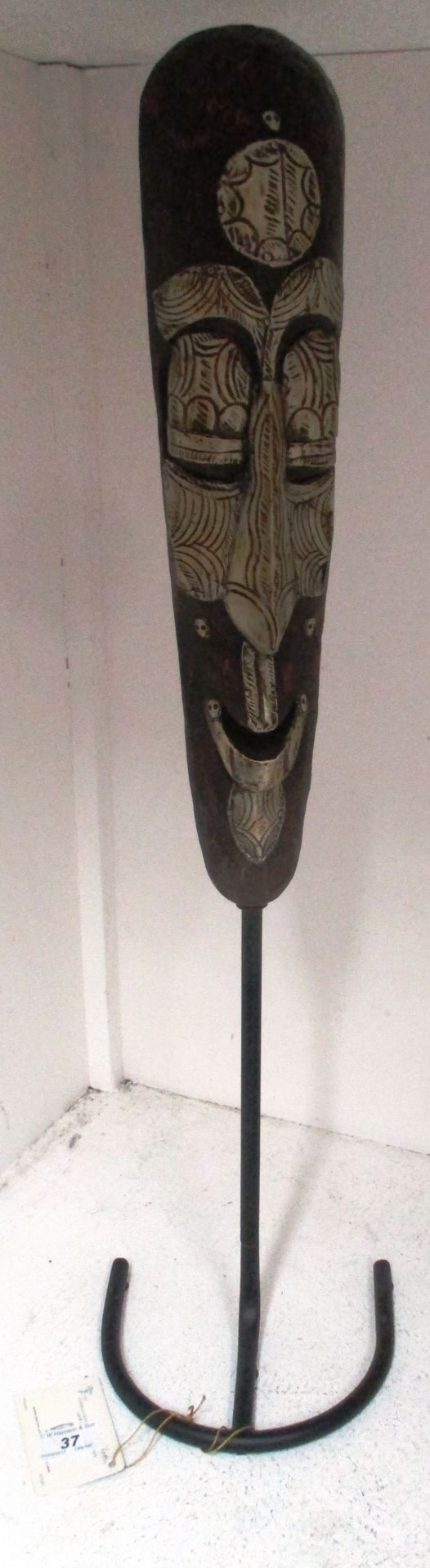 An African carved mask on metal stand