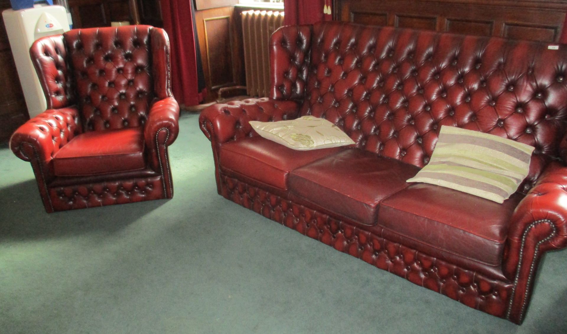 Oxblood leather two piece suite comprising deep button back three seater settee and matching