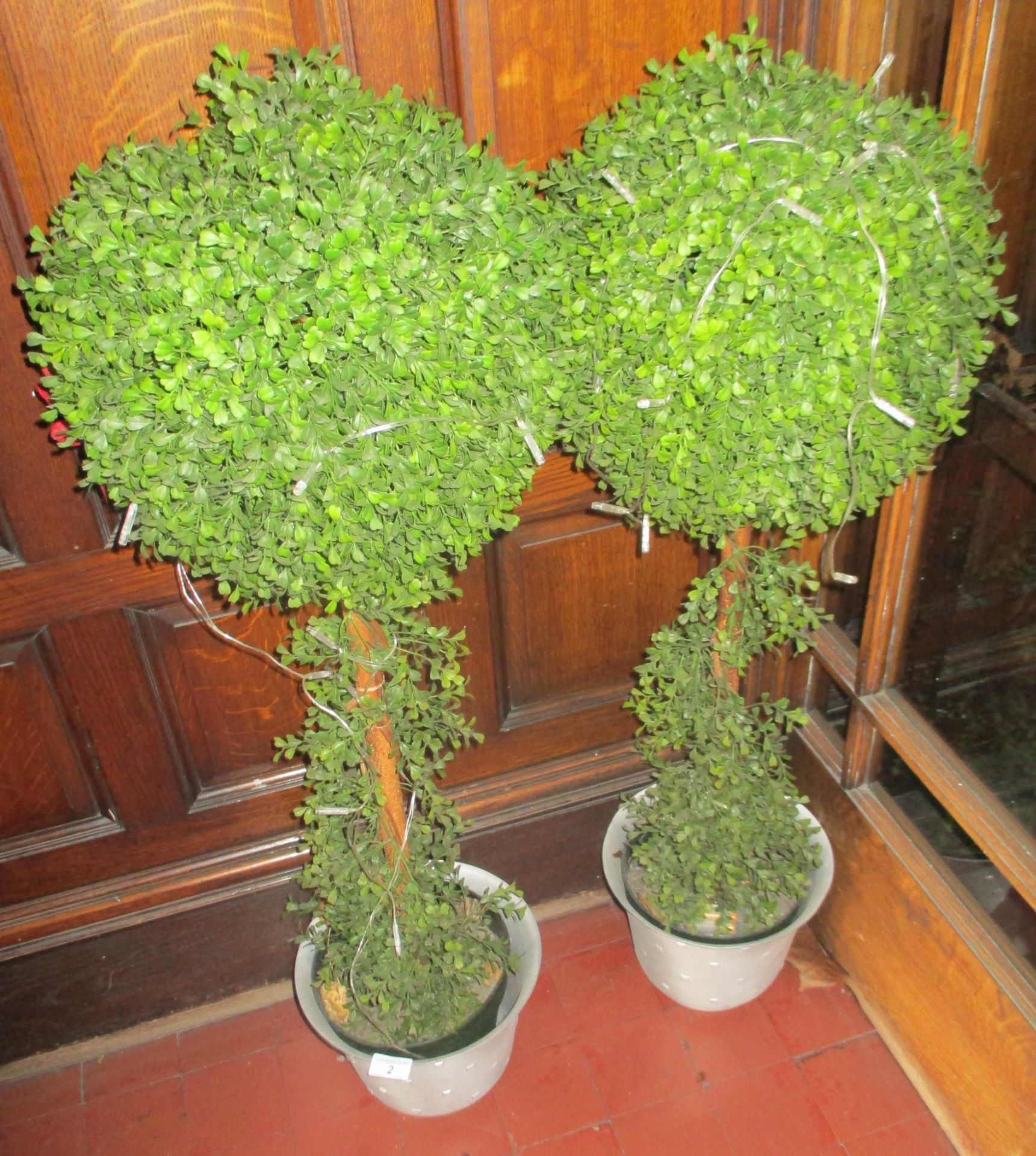 Pair of artificial box trees in planters.