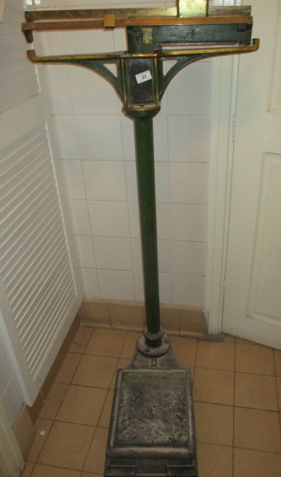 Green metal manual weighing scales to weigh to 24 stone [to gents. toilet].