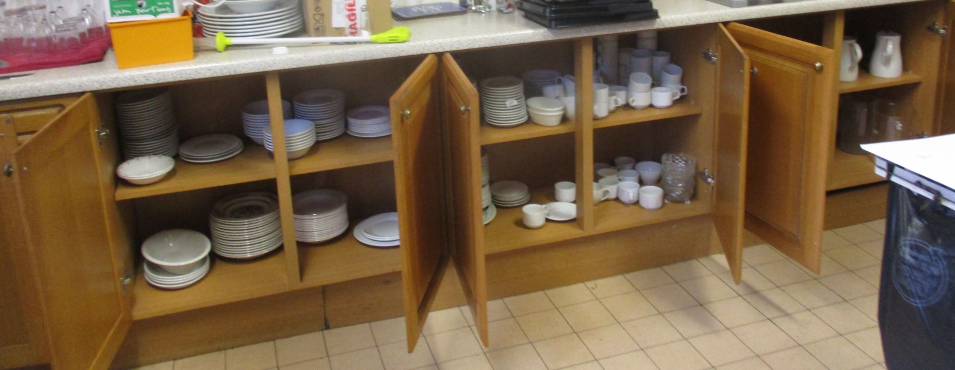 Contents to bottom cupboard - quantity of assorted white catering crockery - teapots, milk jugs,
