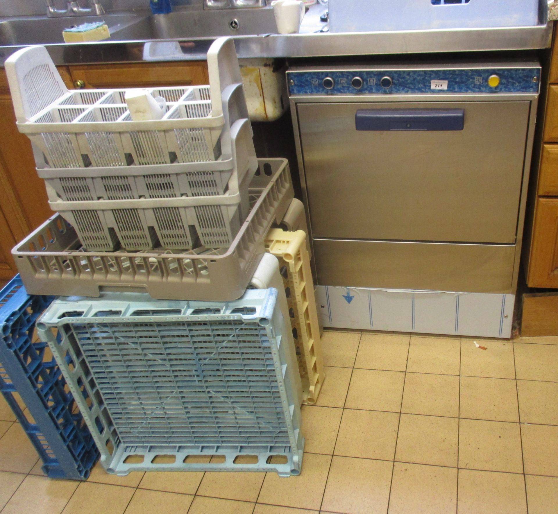 Stainless steel under counter dishwasher and a quantity of plastic trays.