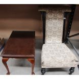 A high back low seat nursing chair with beige floral patterned upholstery and a walnut coffee table