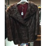 Short dark brown fur jacket.