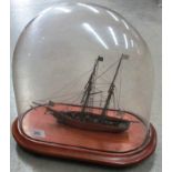 A wooden model of a two masted cutter under a glass dome