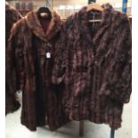 ¾ length brown fur jacket together with a full length mid brown fur coat.