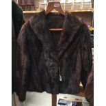Short dark brown fur jacket together with two fur collars.