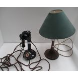 Black metal stick telephone and an oak table lamp with shade