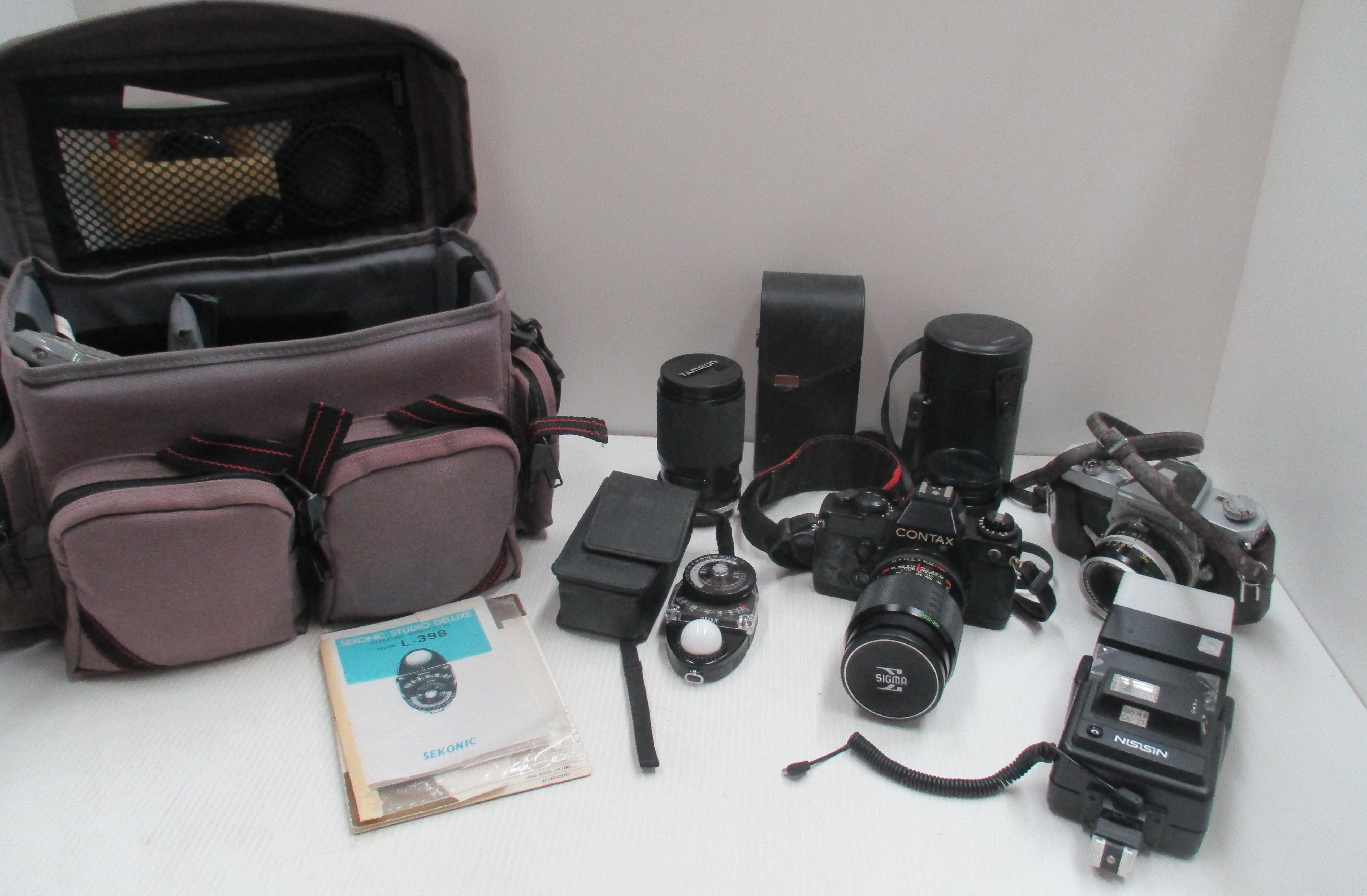 A Contax 139 Quartz camera t/w Sigma 1:28 f= 135mm, a Tamron 38-136mm lens Carl Zeiss Planar 1,