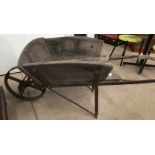 Metal framed wheelbarrow with wooden body.