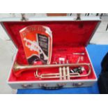 A Conton brass trumpet in case complete with attachments and manual/music book