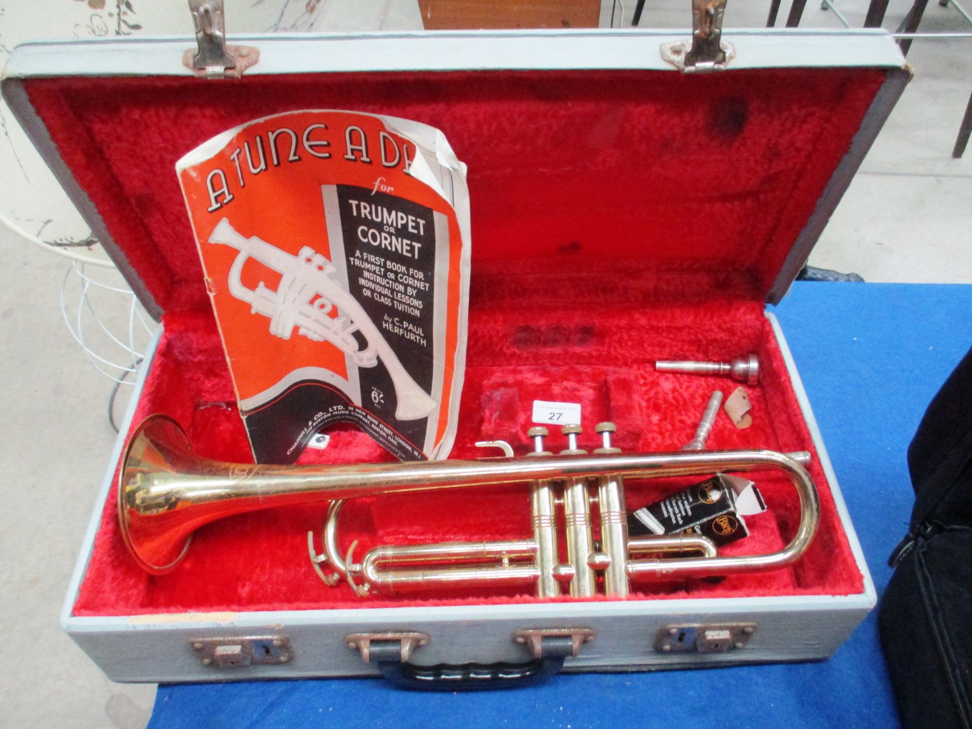 A Conton brass trumpet in case complete with attachments and manual/music book