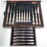 A set of twelve pairs of Victorian dessert knives and forks with embossed silver cased handles in