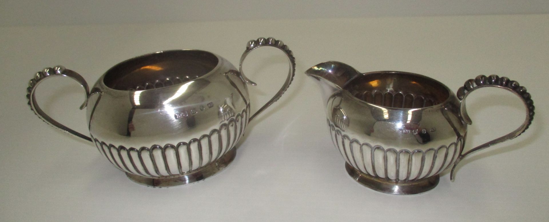 A Victorian silver sugar and cream set, the oval bodies with gadroon decoration and beaded handles,