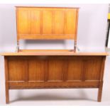 An oak double bedstead with four panel head and foot,