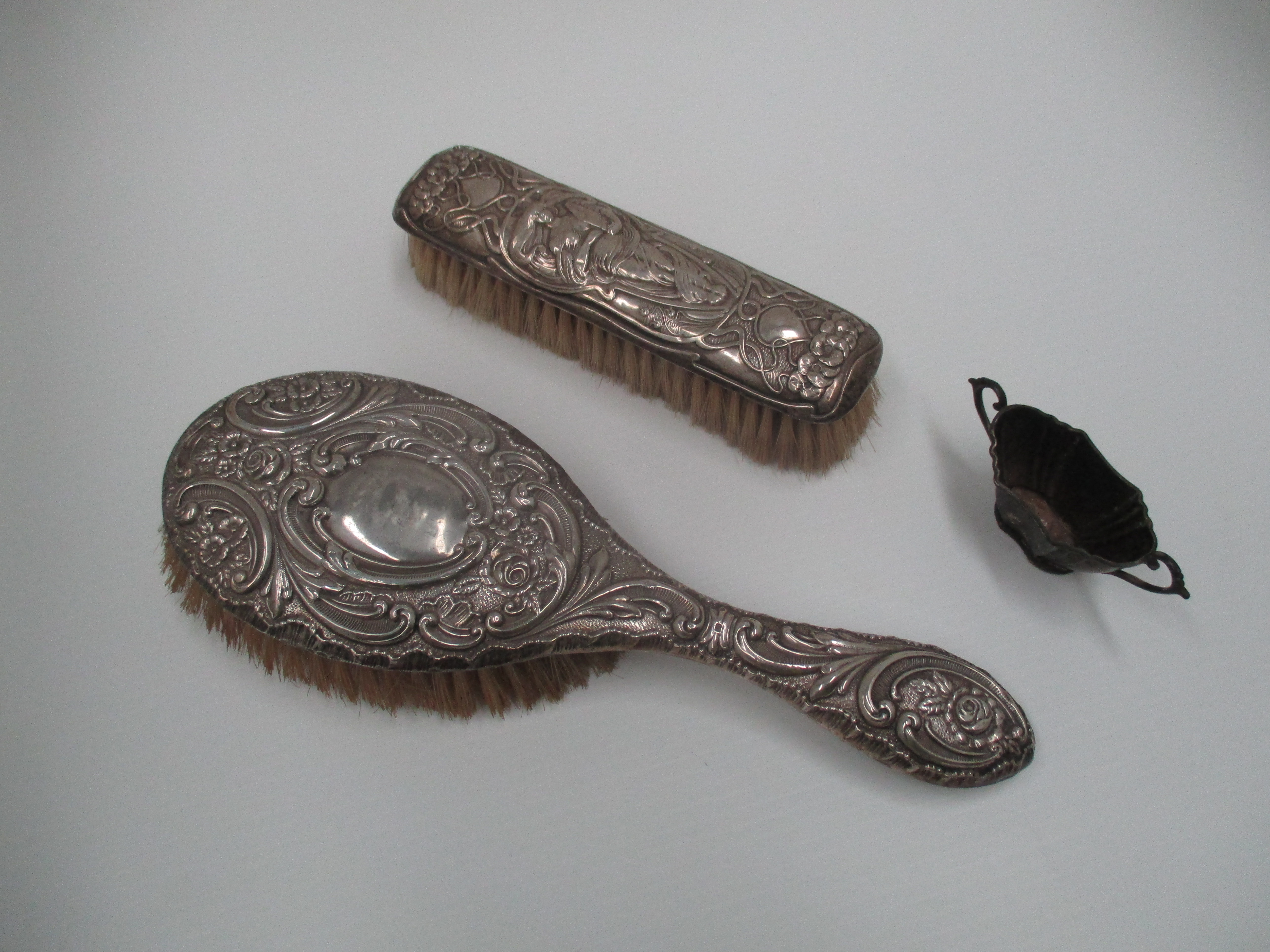 A clothes brush with art nouveau style embossed back,