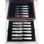 A set of six silver bladed dessert knives with mother of pearl handles and five matching forks [11].