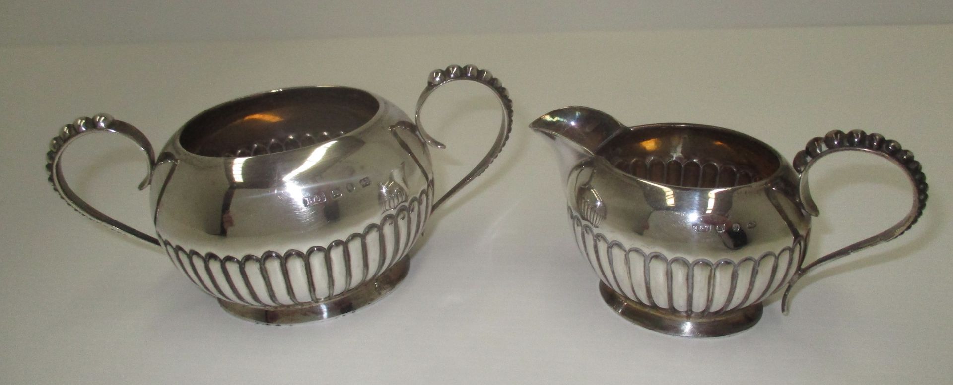 A Victorian silver sugar and cream set, the oval bodies with gadroon decoration and beaded handles, - Image 2 of 2