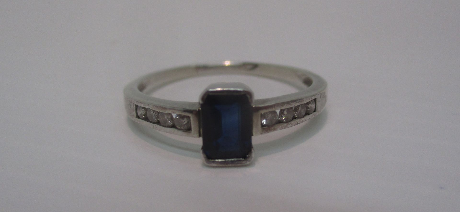 A Sapphire ring, the rectangular stone set in white gold (tested 18ct) with diamond shoulder (2.