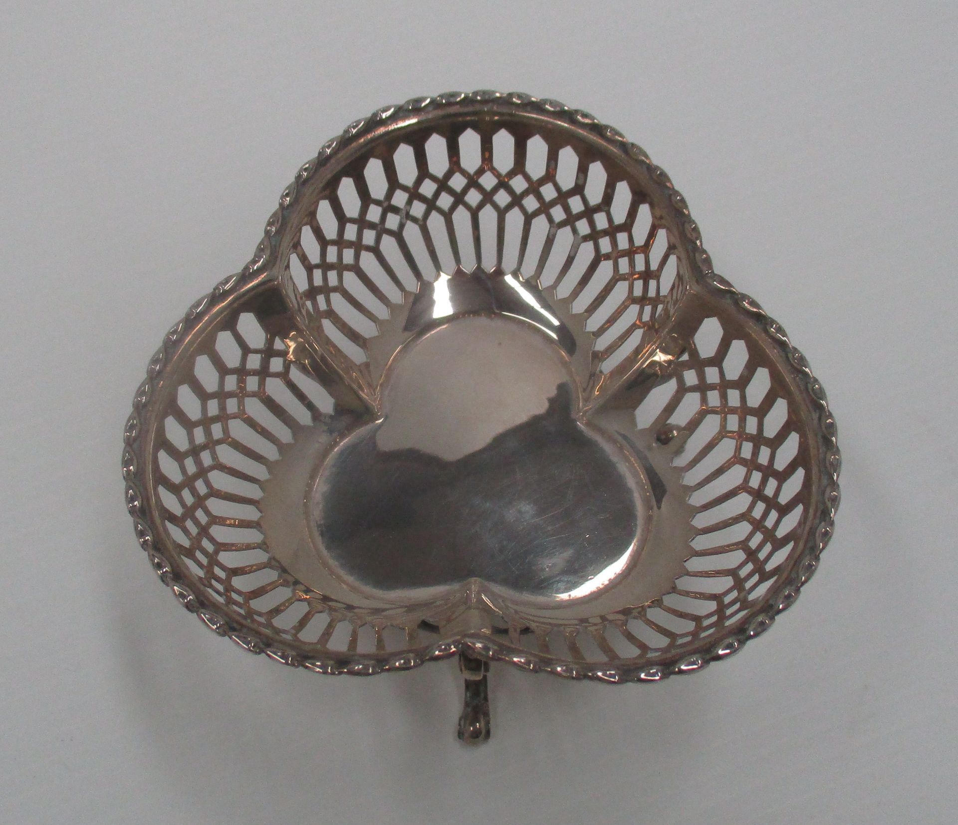 A silver tri-lobe bowl with moulded rim and pierced sides, on three scroll feet, Birmingham 1909, - Image 3 of 3