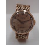 A lady's Rolex wristwatch in 9ct gold case on integrated 9ct gold flexible mesh bracelet.