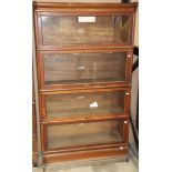 A four section Globe-Wernicke oak bookcase with glazed panel doors on a plinth base with square