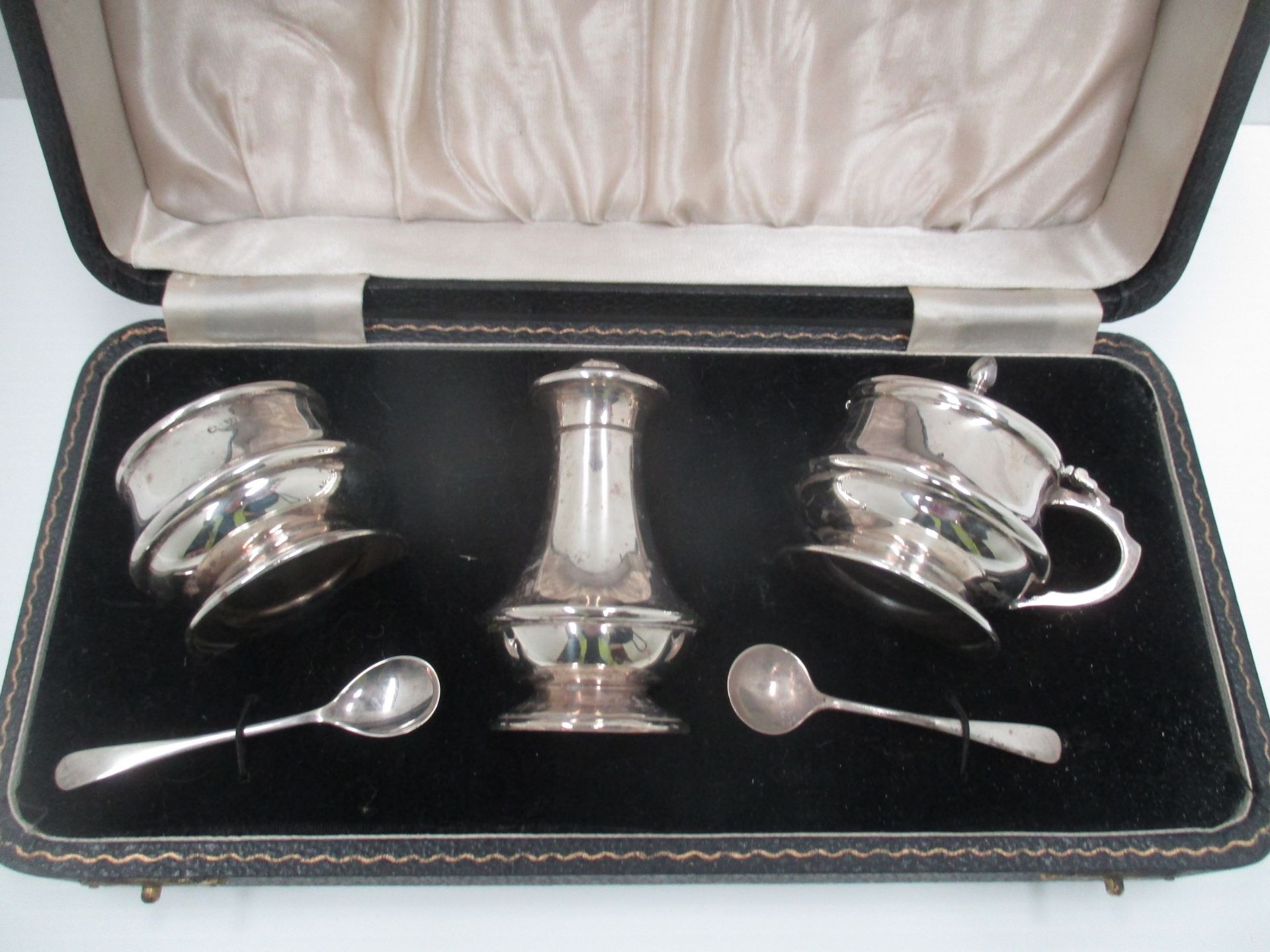 A three piece silver condiment set, the baluster bodies with raised mid bands,