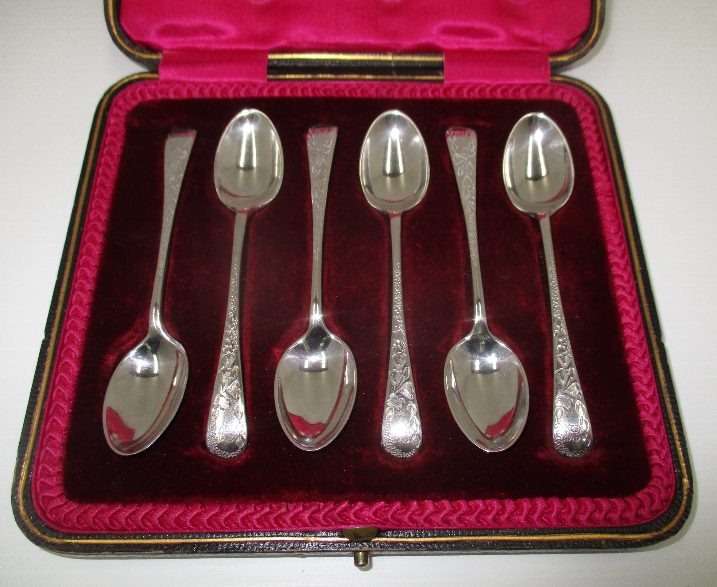 A set of six silver Old English pattern coffee spoons with floral engraved handles,