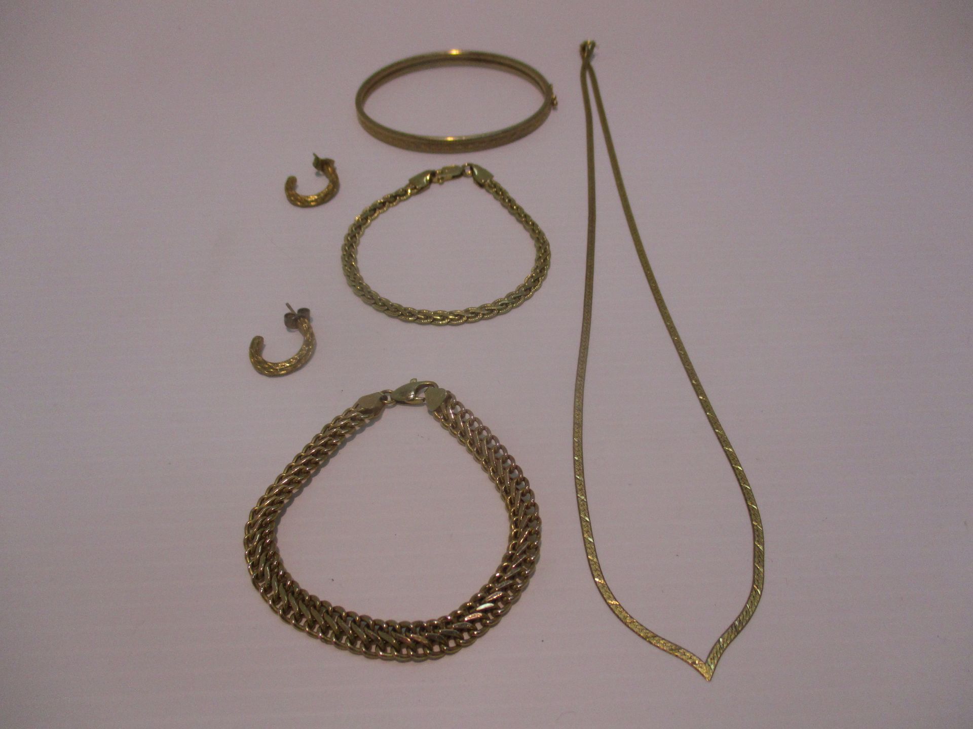 A 9ct gold textured finish necklace, two woven pattern bracelets,