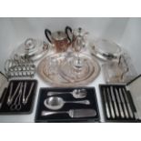 An oval silver plated serving plate, hotel plate, tea and water pots, two toast racks,