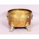 An oval bronze log bucket with lion mask and ring handles, on paw feet - 42 x 35 cm.