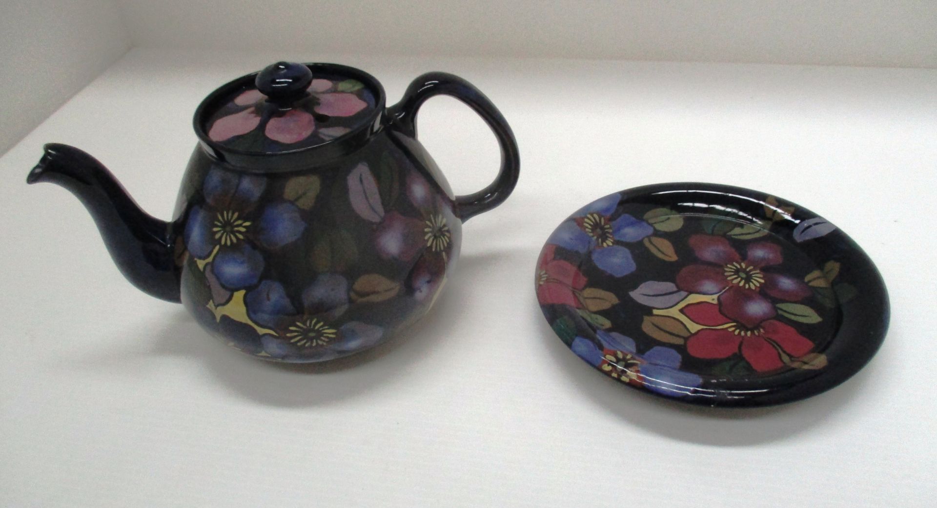 A Royal Stanley terracotta teapot and stand enamelled in floral pattern (2)