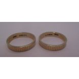 Two 9ct gold wedding rings with reeded decoration [total approximate weight 3.5g.