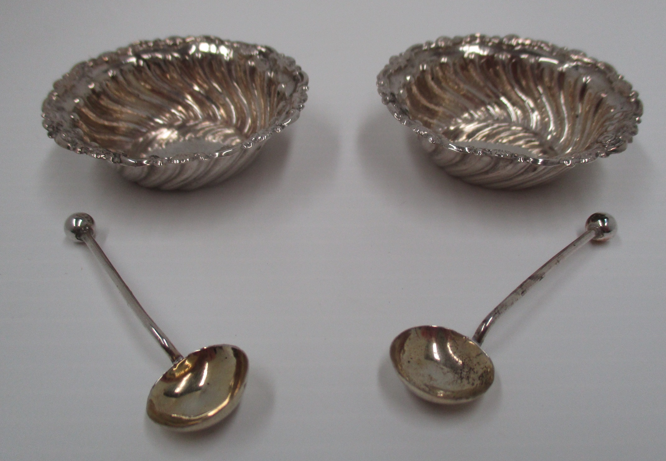 A pair of Victorian circular silver salts with wrythen embossed sides and scroll border and - Image 2 of 2