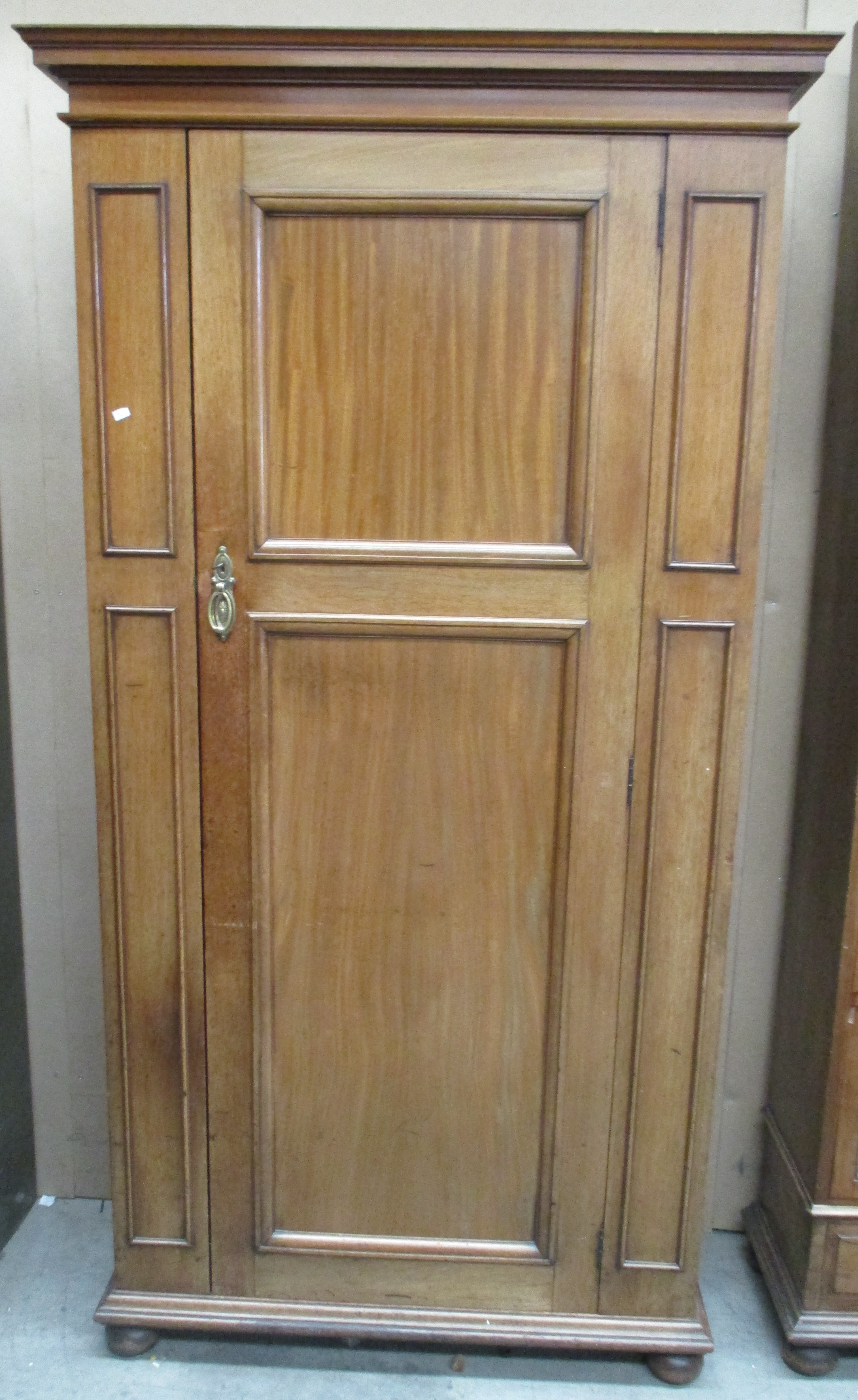 A mahogany hall robe with moulded panel door and sides, on flattened bun feet - 92 cm.