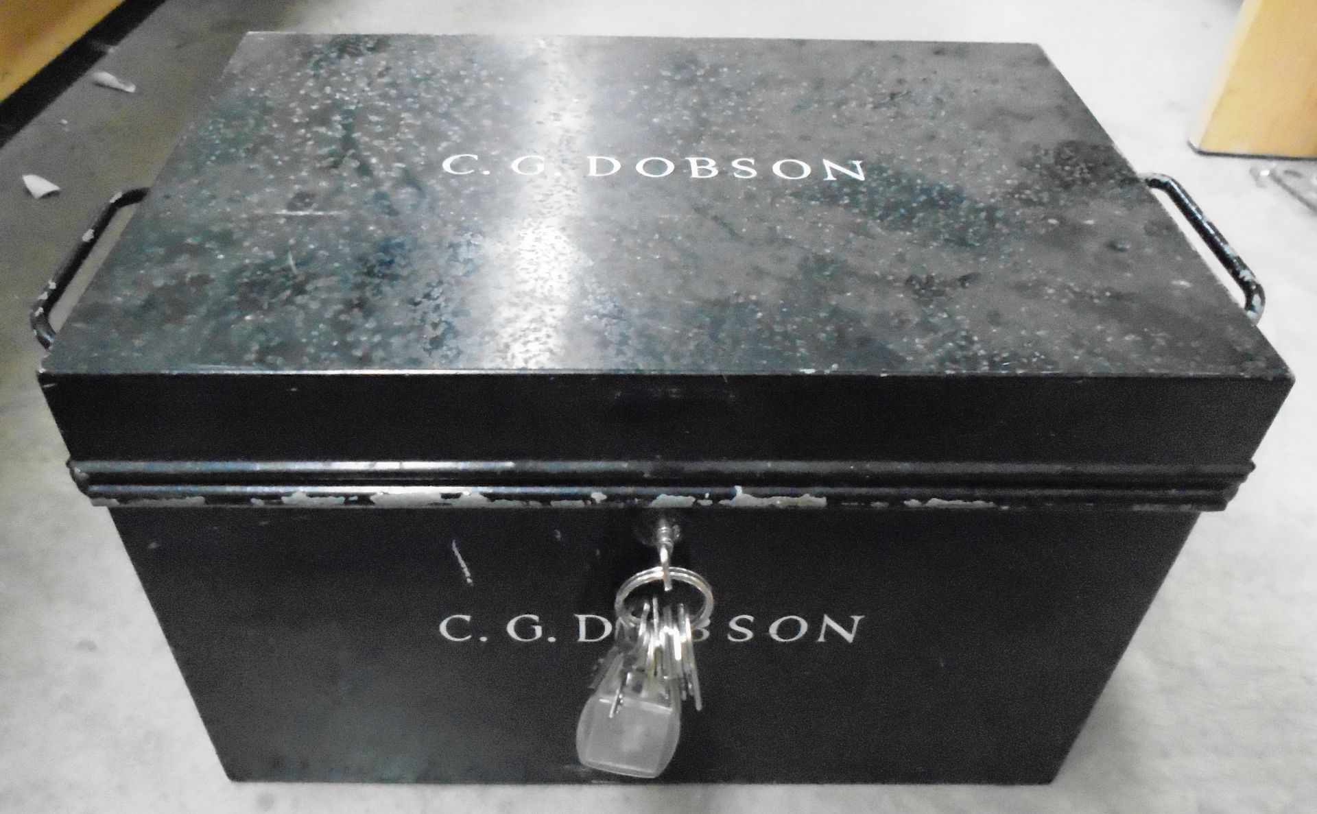 A black metal deed box with 2 handles and keys