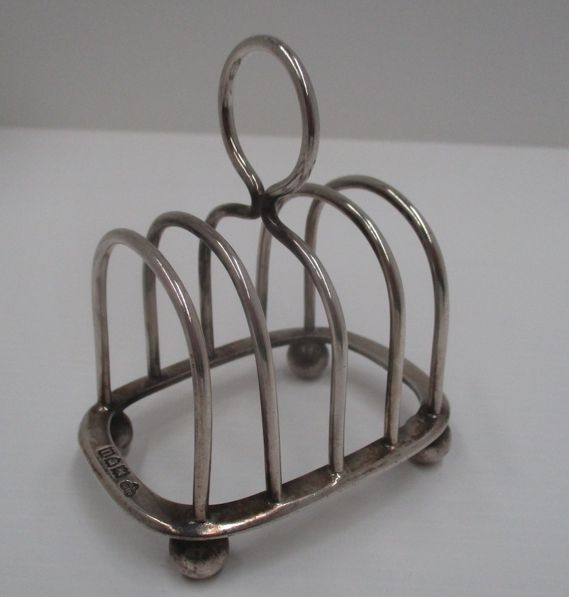 A silver four division toast rack of arched form for Goldsmiths and Silversmiths Co. Ltd.