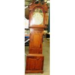 A long-case clock in an oak and mahogany case with scroll pediment and turned pillars over a shaped