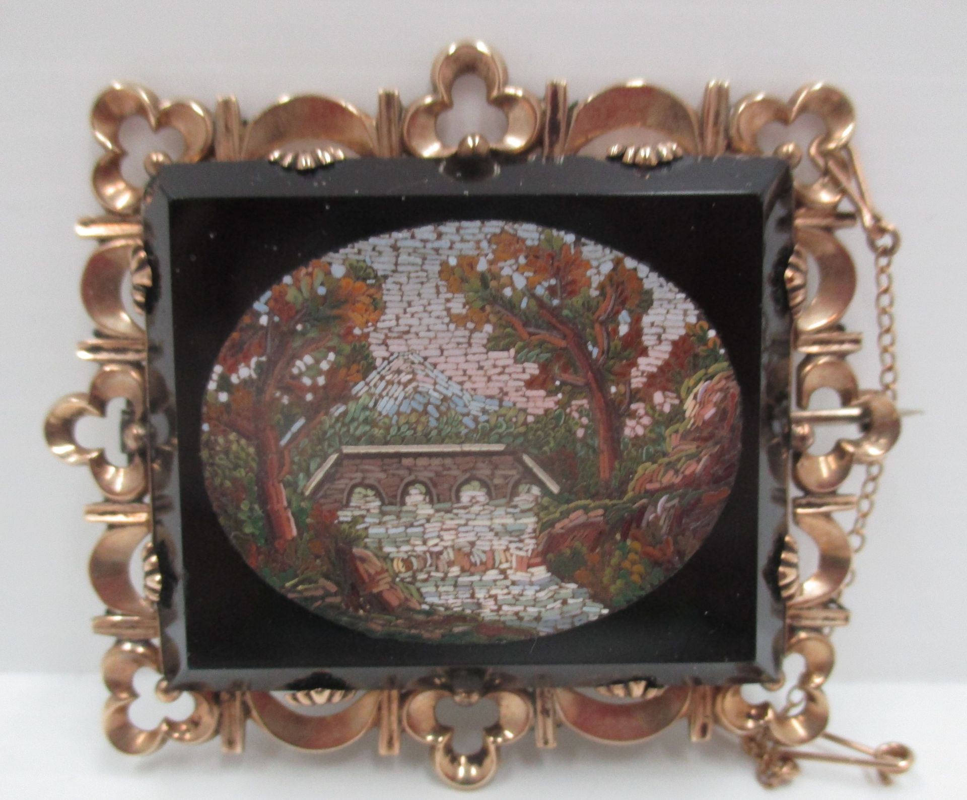 A Victorian rectangular brooch with an oval micro-mosaic panel of a river, bridge and tree,