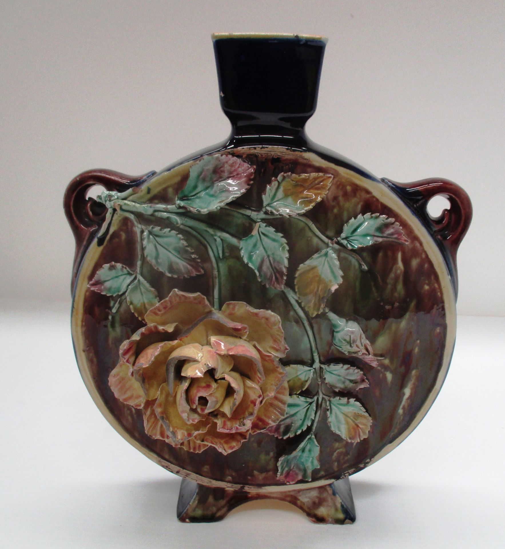 A Victorian pottery moon flask vase in Majolica glazes with applied rose decoration 29.