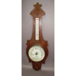 An aneroid barometer and thermometer in shaped oak case,