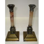 A pair of classical column candlesticks the veined marble pillar with cast brass acanthus capitals,