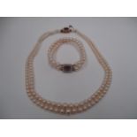 A two strand cultured pearl necklace with 9ct gold fastener set with an amethyst and seed pearls,