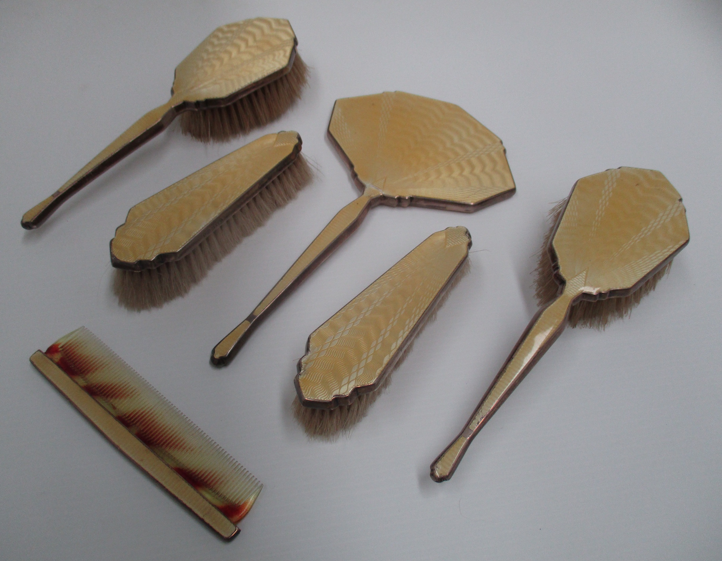 A six piece silver cased dressing table set with engine turned enamel backs [6].