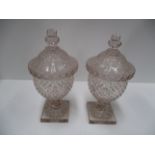 A pair of Early 19th Century covered glass urns with knopped finials,