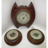 An Aneriod wall barometer in oak 'bat shaped' case 22cm and two small circular barometers (3)