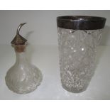 A tapered glass vase in star pattern with a silver rim and a glass oil bottle with silver cap and