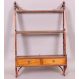 A mahogany hanging wall rack with fretted sides, two shelves over a base of two drawers 91 x 60.